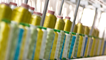 Spools of yellow yarn at a textile manufacturing plant. Credit: ID 5468768 © Hooverphonic | Dreamstime.com