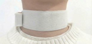 White smart necklace around a neck, featuring a smooth fabric design and a small attachment on the side, worn over a light sweater.