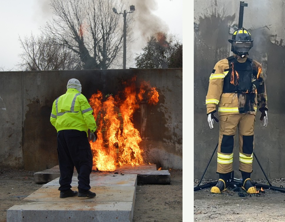 A figure in a bright yellow jacket stands by a fire burning on a concrete slab, while a burned fireman mannequin is displayed beside it.