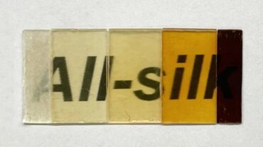 A series of translucent silk swatches in varying shades from light yellow to dark brown, showcasing different textures and finishes.